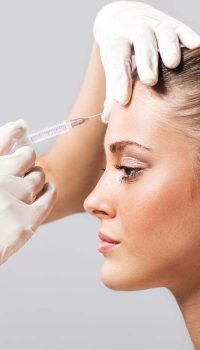 Side view of a young woman receiving botox injection.