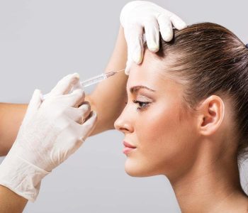 Side view of a young woman receiving botox injection.